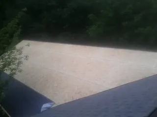 New OSB roof sheathing installed beside an existing shingle roof in Austin