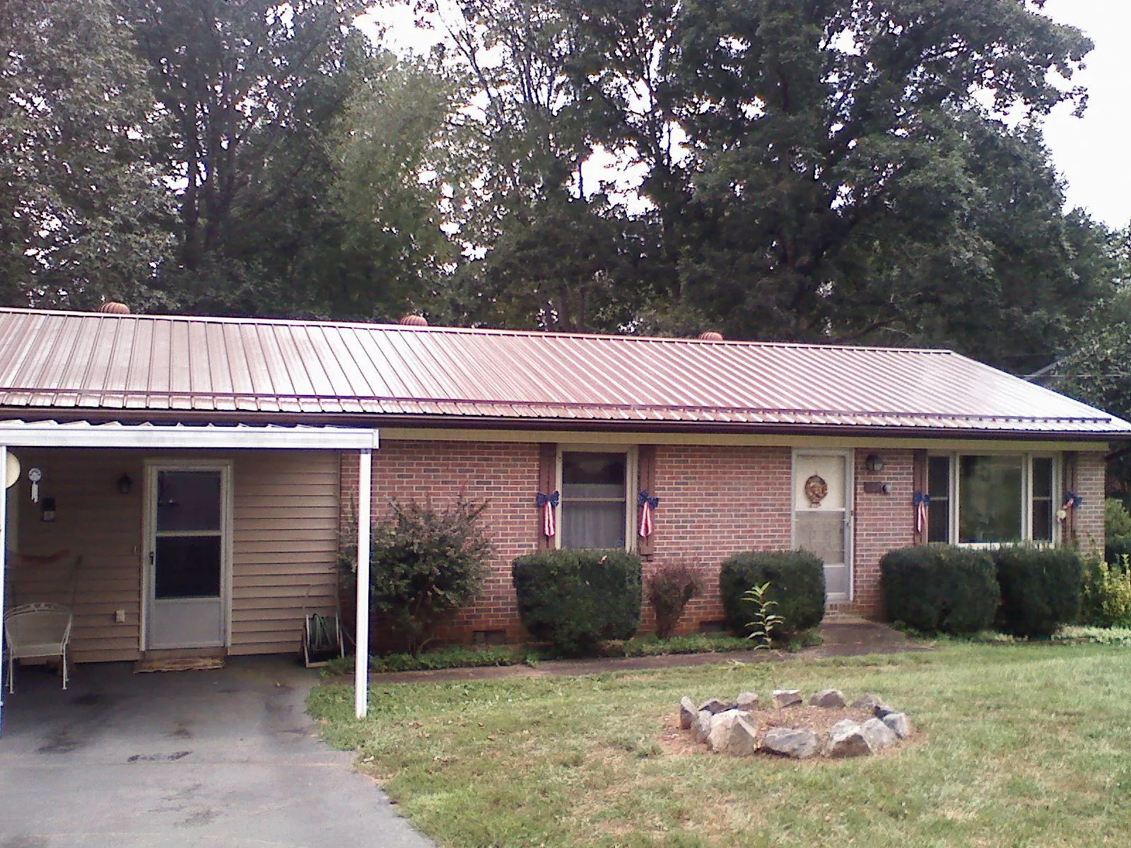 Bronze metal roof and carport on a brick ranch home — Roof Repair work by our crew in Austin
